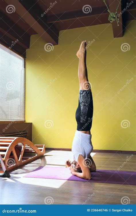 A Woman Performs The Sirshasana Exercise An Inverted Asana Stands On