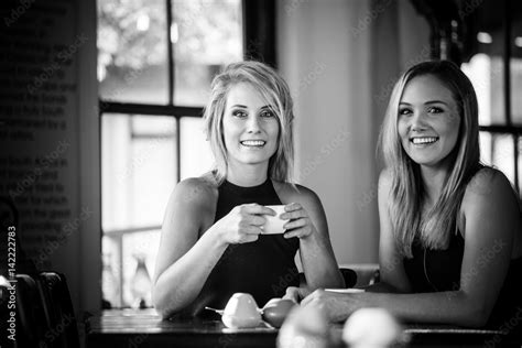 Close Up Image Of Two Young Girlfriends Enjoying A Cup Of Coffee In A
