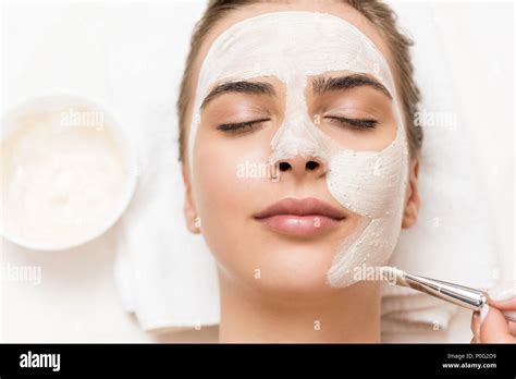 Woman Relaxing And Receiving Facial Mask And Spa Therapy Stock Photo