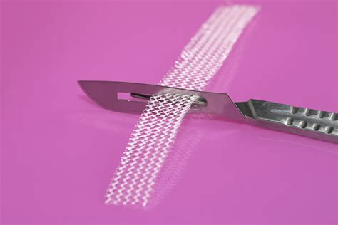 Surgical Knife And Tension Free Vaginal Tape On Pink Background