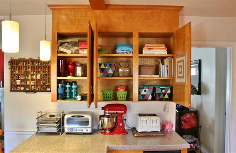 Use every square inch of space by installing a paper towel rack. Organizing Kitchen Cabinets with a Cork Message Center ...
