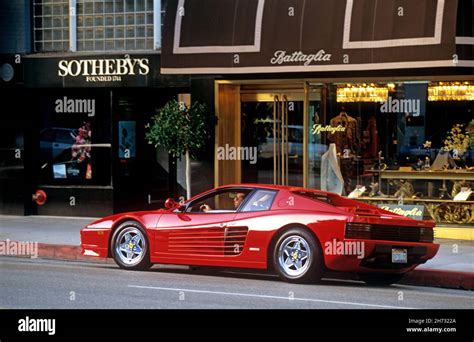 Man Sitting In A Red Ferrari Sports Car Parked On Rodeo Drive In