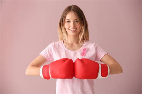 Beautiful Woman With Pink Ribbon And Boxing Gloves On Color Background