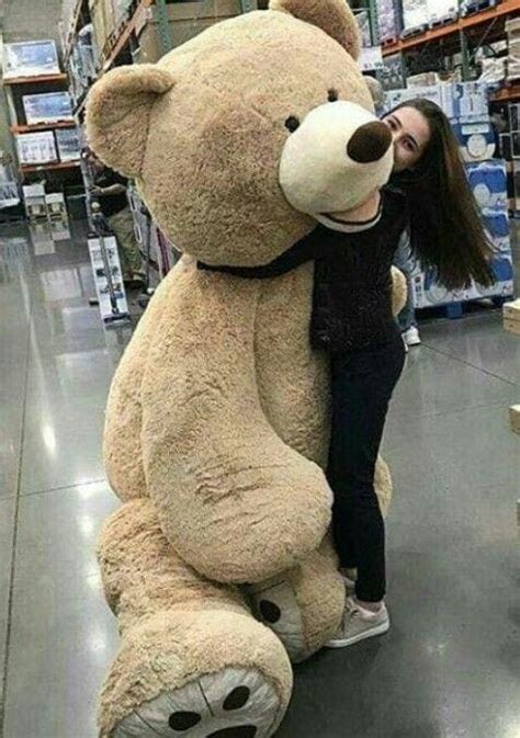 A Woman Hugging A Giant Teddy Bear In A Store