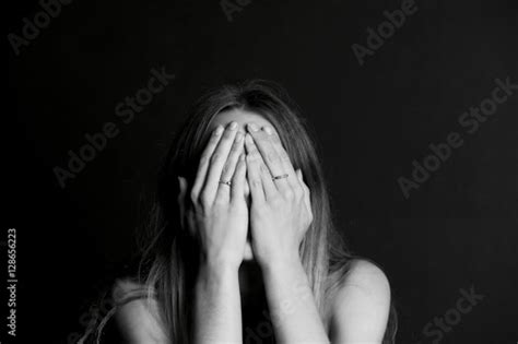 A Young Girl With Long Hair Covering Her Face With Her Hands Bw Stock