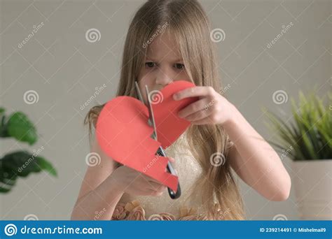 Cute Little Girl Cutting Into Pieces A Red Paper Heart Heartbreak And