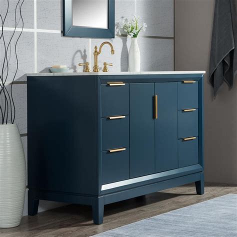 A Bathroom Vanity With Blue Cabinets And Gold Handles
