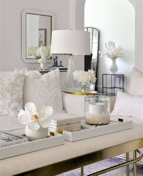 A Living Room Filled With White Furniture And Flowers On Top Of A