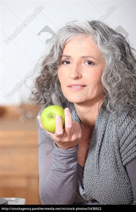 Beautiful Mature Woman Eating Green Apple Royalty Free Image