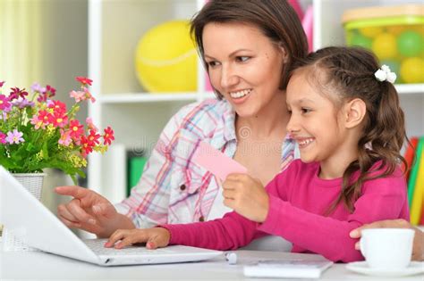 Portrait Of Mother And Daughter Using Laptop Together Stock Photo