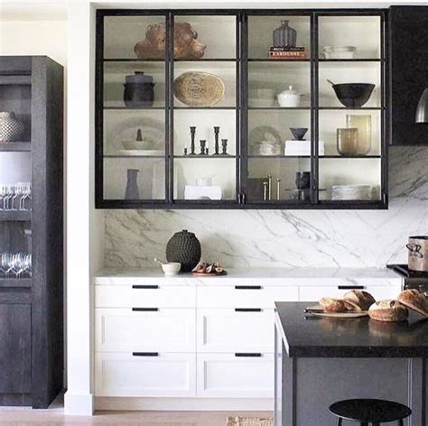 Black And White Kitchen With Glass Front Cabinets And Marble Backsplash