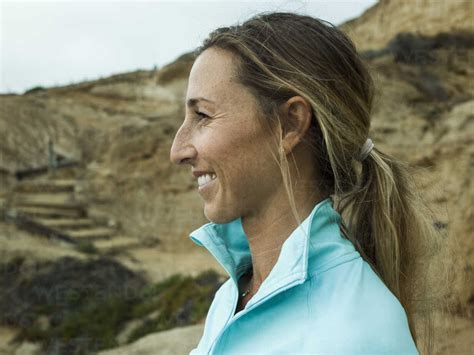 A Smiling Young Woman Side Profile In A Blue Running Top Stock Photo