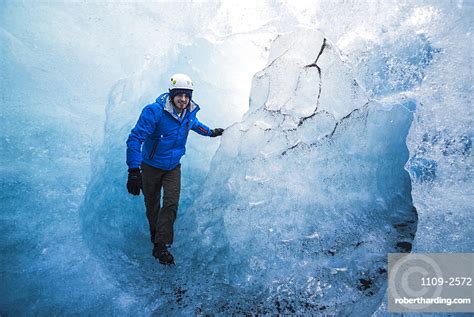 Tourist Exploring An Ice Cave Stock Photo