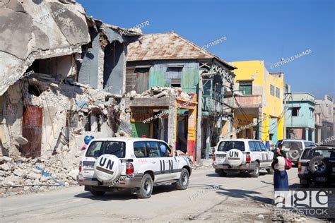 Ruins Of Buildings With United Nations Vehicles Traveling Through A