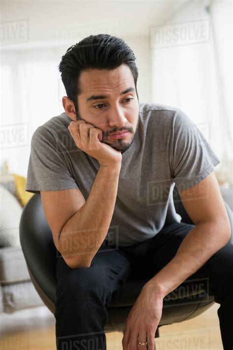 Mixed Race Man Resting Chin In Hand Stock Photo Dissolve