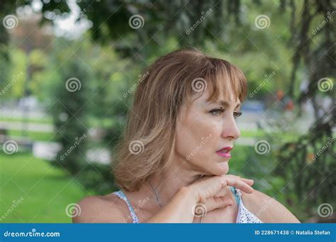 beautiful middle aged woman 50 55 years old with blond hair looking into the distance stock
