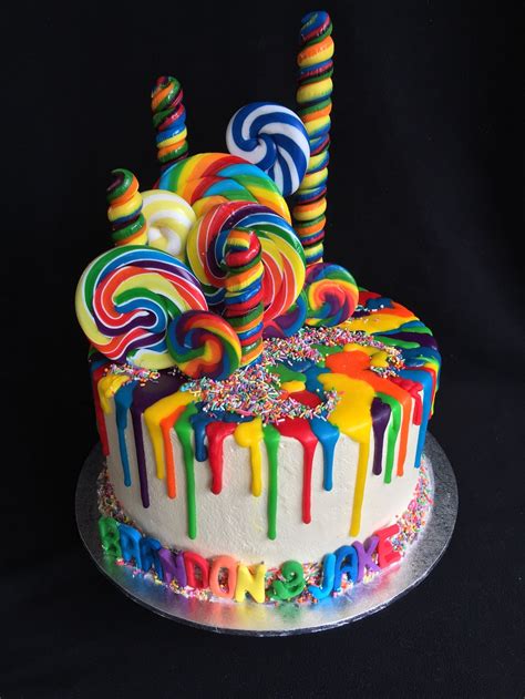 Melt chocolate and butter in a pan set over low heat. Rainbow drip cake with sprinkles and lollipops on white ...