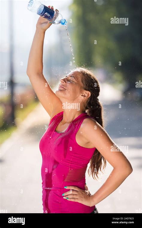 Woman Pouring Water From Bottle On Her Head Stock Photo Alamy