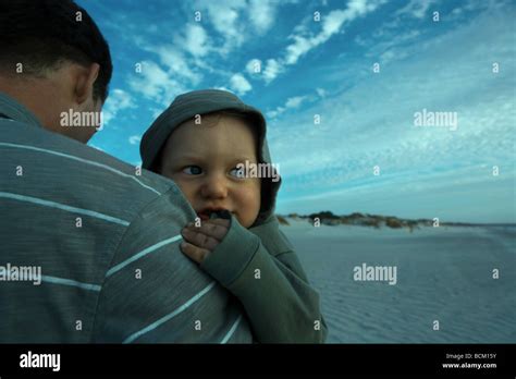 Man Holding Baby On Beach Cropped Stock Photo Alamy