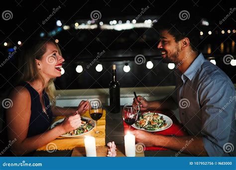 Young Beautiful Couple Having Romantic Dinner On Rooftop Stock Photo