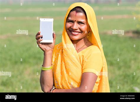 One Rural Female Farmer Showing Mobile Phone Screen In Farm Village