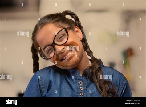 Portrait Of A Smiling Girl In Spectacles With Chocolate Marks Around