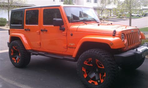 An Orange Jeep Is Parked On The Street