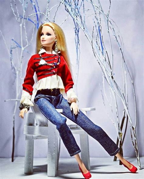 a doll is sitting on a bench in front of some branches