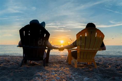 Paare Die Den Sonnenuntergang Auf Strand Aufpassen Stockbild Bild