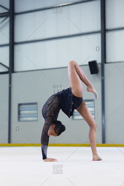 Side View Of Teenage Mixed Race Female Gymnast Performing At Sports