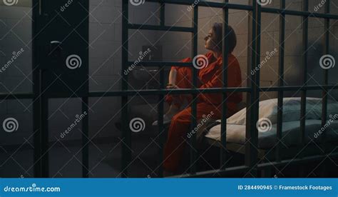 Depressed Female Prisoner Sits On Bed In Prison Cell Stock Image Image Of Punishment Center
