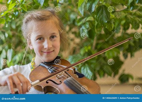 Close Up Of A Child Playing Violin On Green Background Portrait Of