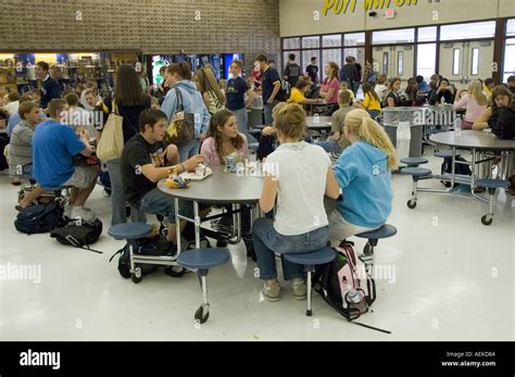 High School Students Eat And Socialize Lunch In A Cafeteria Lunchroom