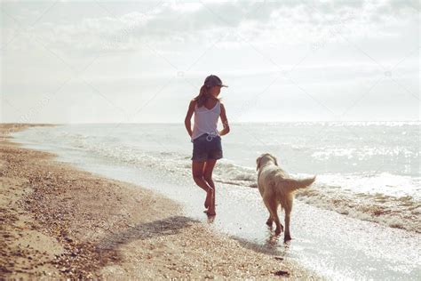 Adolescente Corriendo A Lo Largo De Una Playa Con Su Golden Retriever Durante La Madrugada