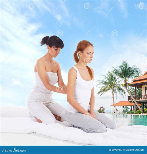 Young Woman Getting Traditional Thai Stretching Massage By Therapist Over Marine Landscape Stock