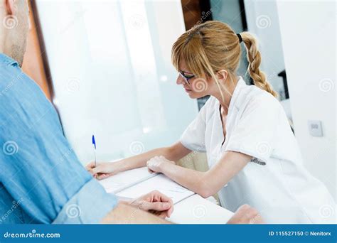 Beautician Preparing Papers To Sign For His Male Client At The Clinic