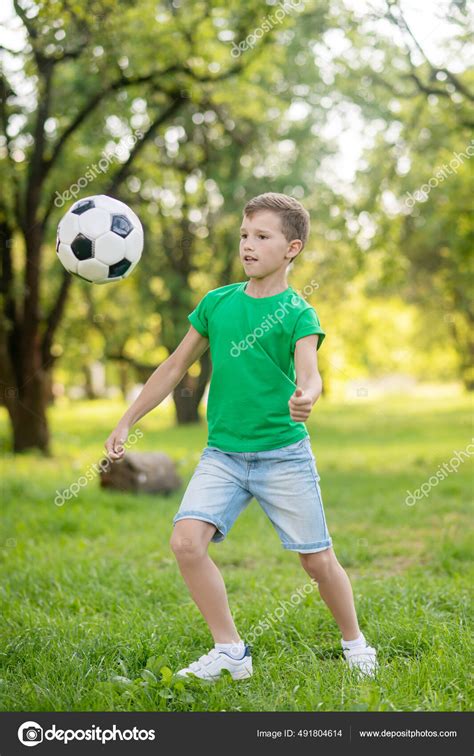 Young Boy Playing Soccer Ball In Park Stock Photo By ©dmyrtoz 491804614