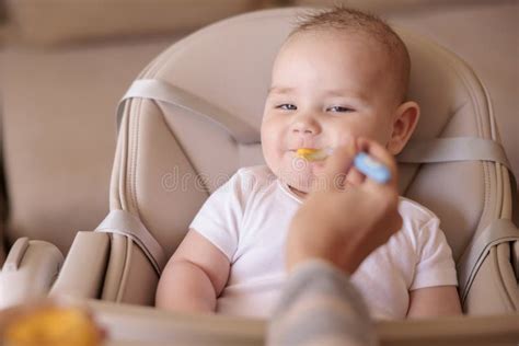Baby Boy Sitting In High Chair Eating Porridge Stock Image Image Of