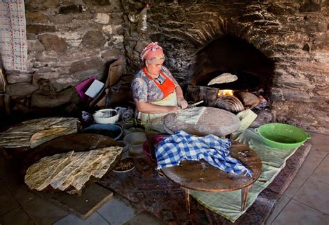 senior woman making pastry for traditional food gozleme inside rustic kitchen of old turkish