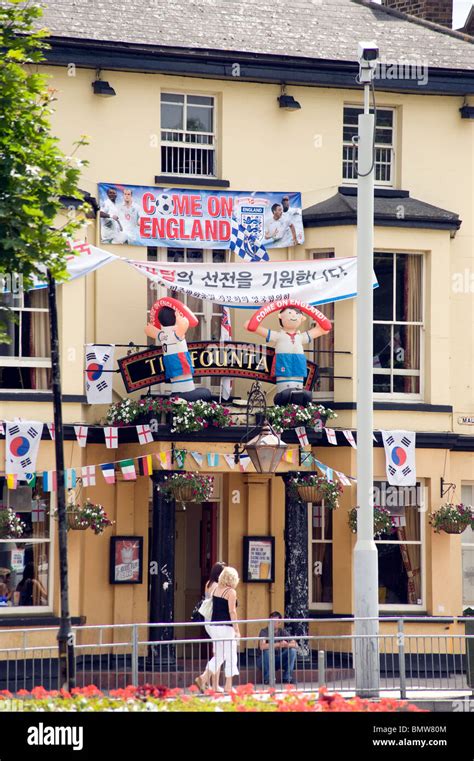Pub Front Festooned With World Cup Flags And Inflatable Football