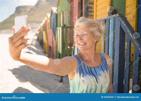 Happy Senior Woman Clicking Selfie While Standing Against Beach Hut Stock Image Image Of