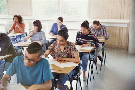 College Students Taking Test At Desks In Classroom Stock Photo Dissolve