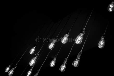 Filtered Image Glowing Light Bulbs Hanging On Black Background Stock