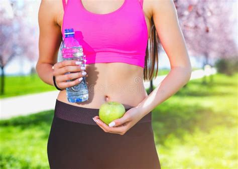 Young Skinny Woman Holding Green Apple And Bottle Of Water Fitness And