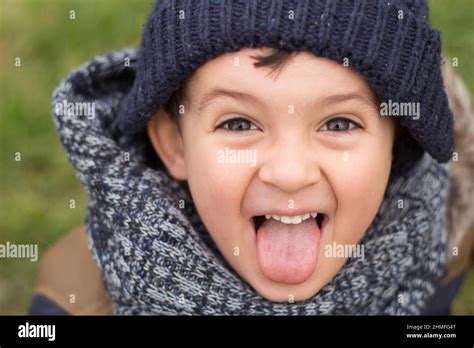 A Little Child Sticking Tongue Out Making Faces Being Silly Happy And