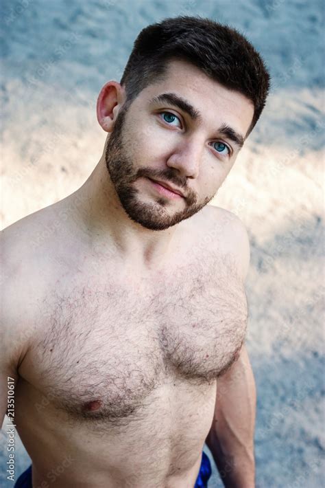 Closeup Portrait Of Sexy Shirtless Hairy Bearded Young Man With Blue