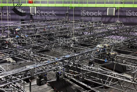 Black Steel Trusses With Moving Head Spotlight Devices Are Lifted By
