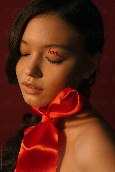 A Closeup Portrait Of An Asian Girl With A Red Belt On Her Neck And A