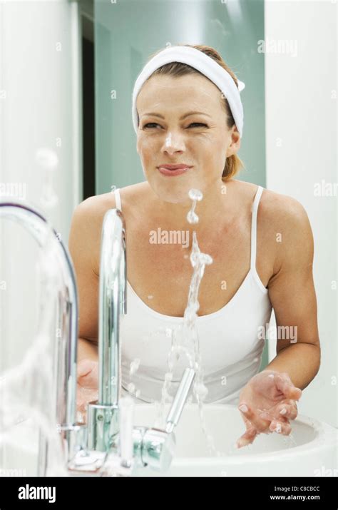 Woman Washing Her Face In Bathroom Stock Photo Alamy