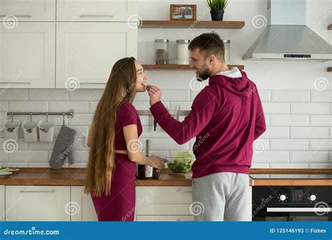 Loving Boyfriend Feeding Girlfriend While Cooking Food Together Stock